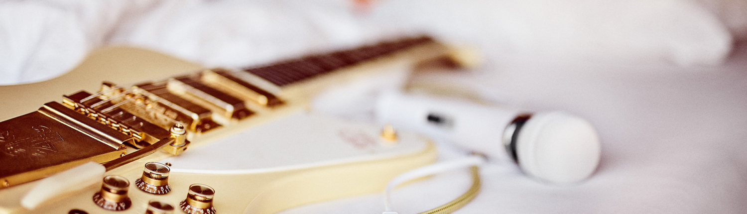 Europe Vitality Wand casually placed on bed next to electric guitar – rock-star self-care morning